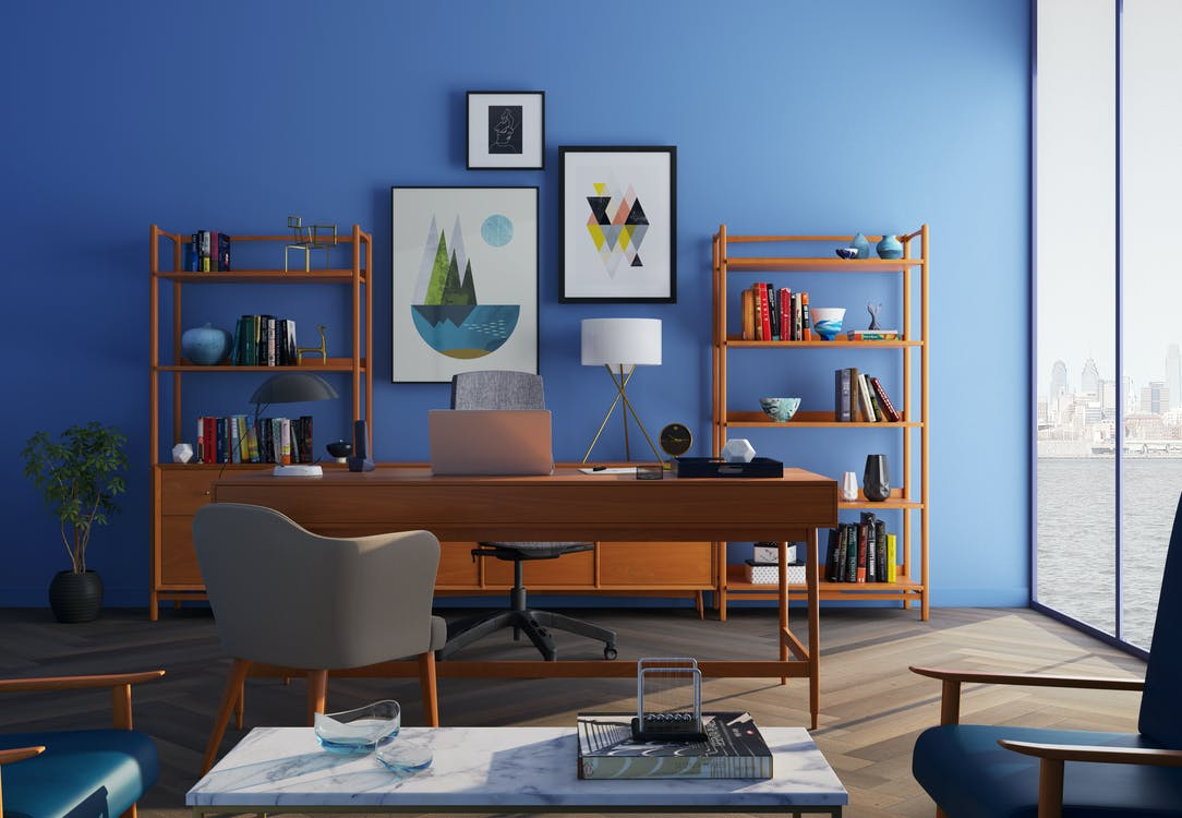 An office space with blue walls and a brown wooden desk