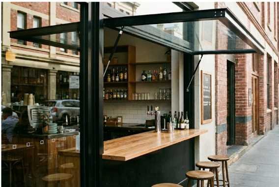 Gas strut window open at a café counter, creating a clear indoor-outdoor serving opening.